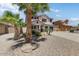 Charming two-story home showcasing a well-manicured desert landscape, palm trees and a three car garage at 14878 W Windrose Dr, Surprise, AZ 85379