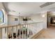 Bright upstairs hallway overlooks the living room with white railings at 14878 W Windrose Dr, Surprise, AZ 85379