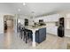 Open kitchen featuring white cabinetry, stainless steel appliances, a large island, and wood look tile flooring at 14878 W Windrose Dr, Surprise, AZ 85379
