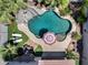 Aerial view of a backyard pool with a slide, lounge chairs, patio furniture, and lush landscaping at 14878 W Windrose Dr, Surprise, AZ 85379