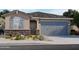 Charming single-Gathering home featuring stone accents, a two-car garage, and professionally landscaped front yard at 16005 W Bronco Trl, Surprise, AZ 85387