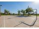 Outdoor basketball court with well-maintained surface and hoops, surrounded by greenery and trees in a community park at 1625 W Gunstock Loop, Chandler, AZ 85286