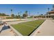 Spacious bocce ball court with lush green lanes, palm trees, and community amenities in view at 1625 W Gunstock Loop, Chandler, AZ 85286