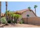 Desert landscaping and stone facade with palm trees offer curb appeal, while a private gate adds security at 1625 W Gunstock Loop, Chandler, AZ 85286
