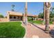 Back exterior of a home with palms and lush lawn with lake views, creating a private oasis at 1625 W Gunstock Loop, Chandler, AZ 85286