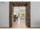 Arched stone doorway leading to a kitchen with bar seating and a living room with neutral furniture at 1625 W Gunstock Loop, Chandler, AZ 85286