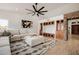 Open living area featuring a sectional sofa, ceiling fan, and custom built-in cabinets with display shelves at 1625 W Gunstock Loop, Chandler, AZ 85286