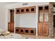Close-up of custom built-in cabinets with display shelves and a stone accent wall in the living area at 1625 W Gunstock Loop, Chandler, AZ 85286