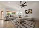 Bright living room featuring a large sectional sofa, ceiling fan, and several large windows for natural light at 1625 W Gunstock Loop, Chandler, AZ 85286