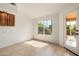 Bright, minimalist living room with tile floors, neutral walls, and a view of the lush outdoor landscape at 1625 W Gunstock Loop, Chandler, AZ 85286