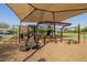 Modern playground structure with climbing features, slide, and sunshade, set on a mulch surface in a park at 1625 W Gunstock Loop, Chandler, AZ 85286