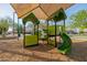 Colorful playground equipment with slide and learning panels, shaded with a canopy, and surrounded by greenery at 1625 W Gunstock Loop, Chandler, AZ 85286