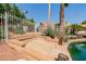 Charming waterfront patio with lush landscaping, mature trees, and a glimpse of the serene lake at 1625 W Gunstock Loop, Chandler, AZ 85286