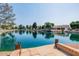 Stunning lake view with a stone patio, wooden posts, and beautiful homes in the background at 1625 W Gunstock Loop, Chandler, AZ 85286