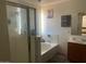 Well-lit bathroom featuring a shower, tub, and wooden vanity at 17335 W Woodlands Ave, Goodyear, AZ 85338