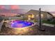 A backyard oasis featuring a uniquely shaped pool with rock landscaping and easy access to covered patio at 18630 W Lawrence Ln, Waddell, AZ 85355