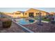 Spacious backyard with a shimmering pool, a patio area, and green turf at 18630 W Lawrence Ln, Waddell, AZ 85355