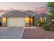 Charming single-story home featuring a stucco exterior and a two-car garage at dusk at 18630 W Lawrence Ln, Waddell, AZ 85355