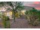 Single-story home showcasing desert landscaping and a quaint front facade at dusk at 18630 W Lawrence Ln, Waddell, AZ 85355