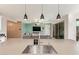 Kitchen island sink and modern fixtures with living room in the background at 18630 W Lawrence Ln, Waddell, AZ 85355