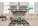 Close up of a kitchen with a stainless steel stovetop and stylish backsplash at 18630 W Lawrence Ln, Waddell, AZ 85355