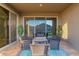 Cozy covered patio with comfortable seating around a fire pit and sliding glass doors at 18630 W Lawrence Ln, Waddell, AZ 85355