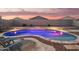 A kidney-shaped pool and raised spa are surrounded by desert landscaping in this serene backyard at 18630 W Lawrence Ln, Waddell, AZ 85355