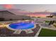 Inviting backyard pool and spa with travertine surround and rock landscaping offers a relaxing outdoor retreat at 18630 W Lawrence Ln, Waddell, AZ 85355