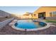 Relaxing pool area with a rock waterfall feature and attractive stone borders at 18630 W Lawrence Ln, Waddell, AZ 85355
