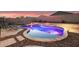 Backyard pool and rock landscaping provide an outdoor escape for relaxing and enjoying desert nights at 18630 W Lawrence Ln, Waddell, AZ 85355
