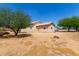 View of the side of the house, set in a spacious backyard, surrounded by mature trees at 2131 E Rose Garden Ln, Phoenix, AZ 85024