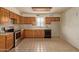 Bright kitchen featuring oak cabinets, stainless steel stove, tile floor, and natural light at 2131 E Rose Garden Ln, Phoenix, AZ 85024