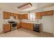 Bright kitchen featuring oak cabinets, stainless steel stove, tile floor, and natural light at 2131 E Rose Garden Ln, Phoenix, AZ 85024