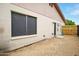 Exterior view of the home featuring large window, door, and access to backyard at 2320 W El Alba Way, Chandler, AZ 85224