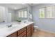 Well-lit bathroom featuring double sinks, wood cabinets, and tile flooring, offering functionality and style at 2331 E Sunland Ave, Phoenix, AZ 85040