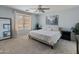 Serene bedroom with a ceiling fan, neutral carpet, and a large window for natural light at 2331 E Sunland Ave, Phoenix, AZ 85040