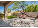 Private backyard with covered patio, stone pavers, green grass and mature trees at 2409 W Red Range Way, Phoenix, AZ 85085