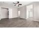 A large bedroom area with a ceiling fan, wood-look tile flooring, and a walk-in closet at 2409 W Red Range Way, Phoenix, AZ 85085