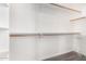 Bright walk-in closet features wood rods and white shelving, providing ample storage space at 2409 W Red Range Way, Phoenix, AZ 85085