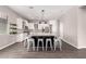 Bright kitchen featuring an island with seating, white cabinets, stainless steel appliances and wood-look tile flooring at 2409 W Red Range Way, Phoenix, AZ 85085
