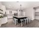 A kitchen area with white cabinets, stainless steel appliances, a center island, and wood-look tile flooring at 2409 W Red Range Way, Phoenix, AZ 85085