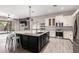 Open kitchen features a large island, granite countertops, stainless steel appliances, and wood-look tile flooring at 2409 W Red Range Way, Phoenix, AZ 85085
