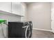 Laundry room with overhead storage cabinets and appliances at 2409 W Red Range Way, Phoenix, AZ 85085