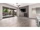 Open-concept living room with wood look tile, modern ceiling fan and a decorative fireplace feature wall at 2409 W Red Range Way, Phoenix, AZ 85085