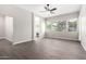A living room area with wood-look tile flooring and several windows allowing for an abundance of natural light at 2409 W Red Range Way, Phoenix, AZ 85085