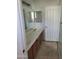 Bathroom featuring double sink, wood cabinets, light colored countertops, and tile floors at 26022 N Sandstone Way, Surprise, AZ 85387