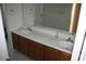 Bathroom featuring double sink vanity with a large mirror and a shower with sliding doors at 26022 N Sandstone Way, Surprise, AZ 85387