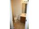 Cozy powder room featuring tile floors, a wooden vanity, and a neutral color scheme at 26022 N Sandstone Way, Surprise, AZ 85387
