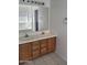 Bathroom features a double sink vanity with light colored countertop, wood cabinets, and a large mirror at 26022 N Sandstone Way, Surprise, AZ 85387