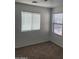Bedroom featuring two windows, neutral carpet, white walls, and light from the windows at 26022 N Sandstone Way, Surprise, AZ 85387